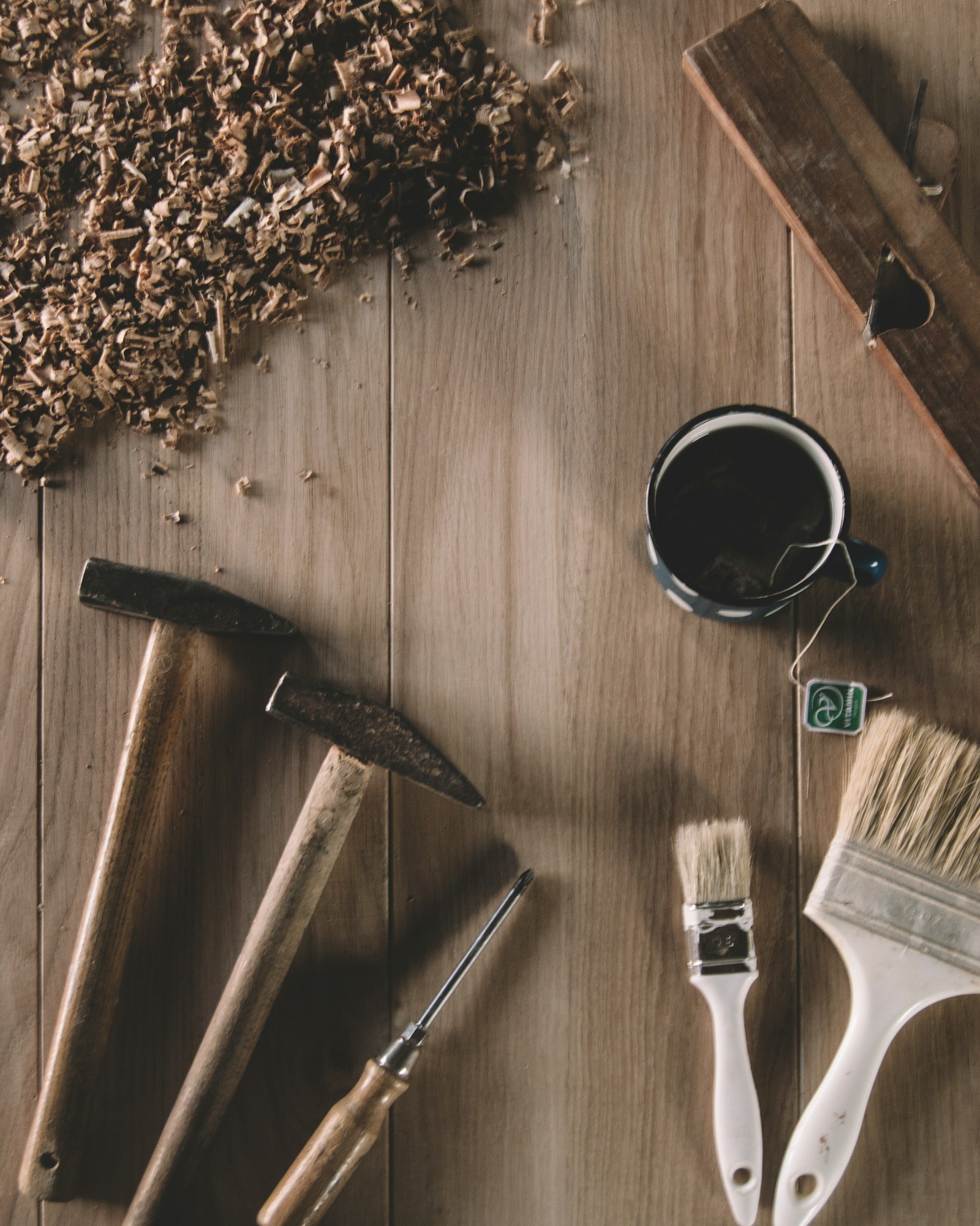 An axe, a mug, and brushes on a wooden surface